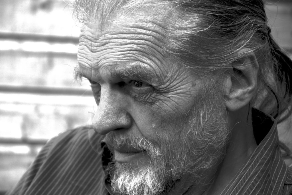 close up black and white photo of a white bearded man