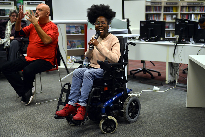 black woman, wheelchair user,  with microphonewith 