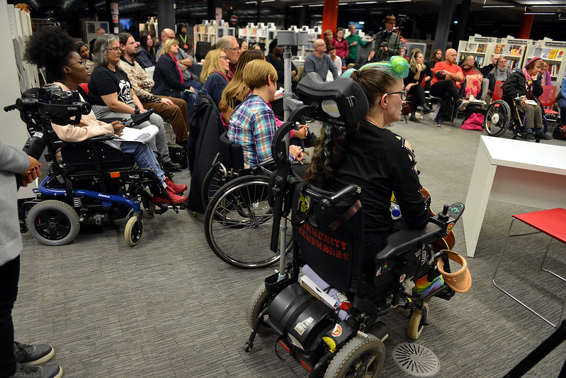 seated audience in a semi circle, 3 in wheelchairs