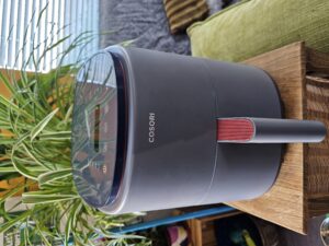 grey air fryer, on stand with plant